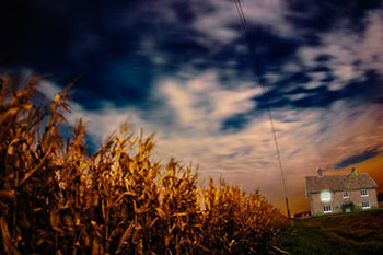 Corn field & farm house at night