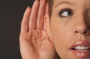 Woman with hand cupped to ear