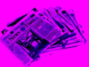 Purple stack of newspapers on a bright pink background