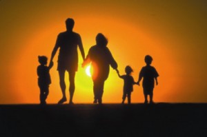 Silhouetted family holding hands